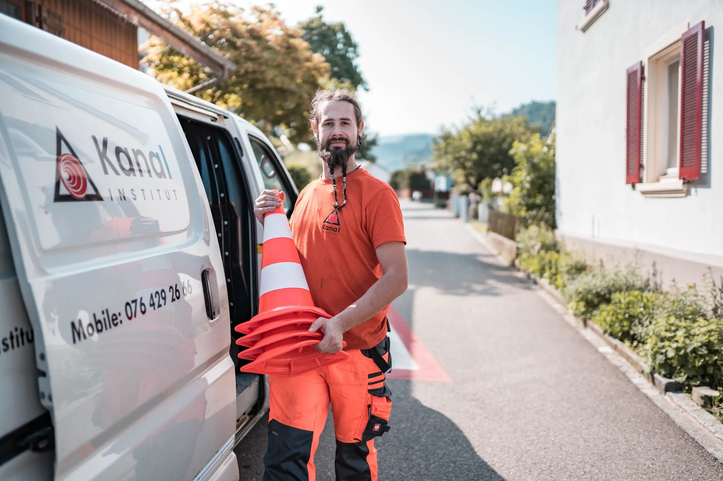 Mitarbeiter der Kanal-Institut AG am Servicefahrzeug in einem Schweizer Wohnquartier